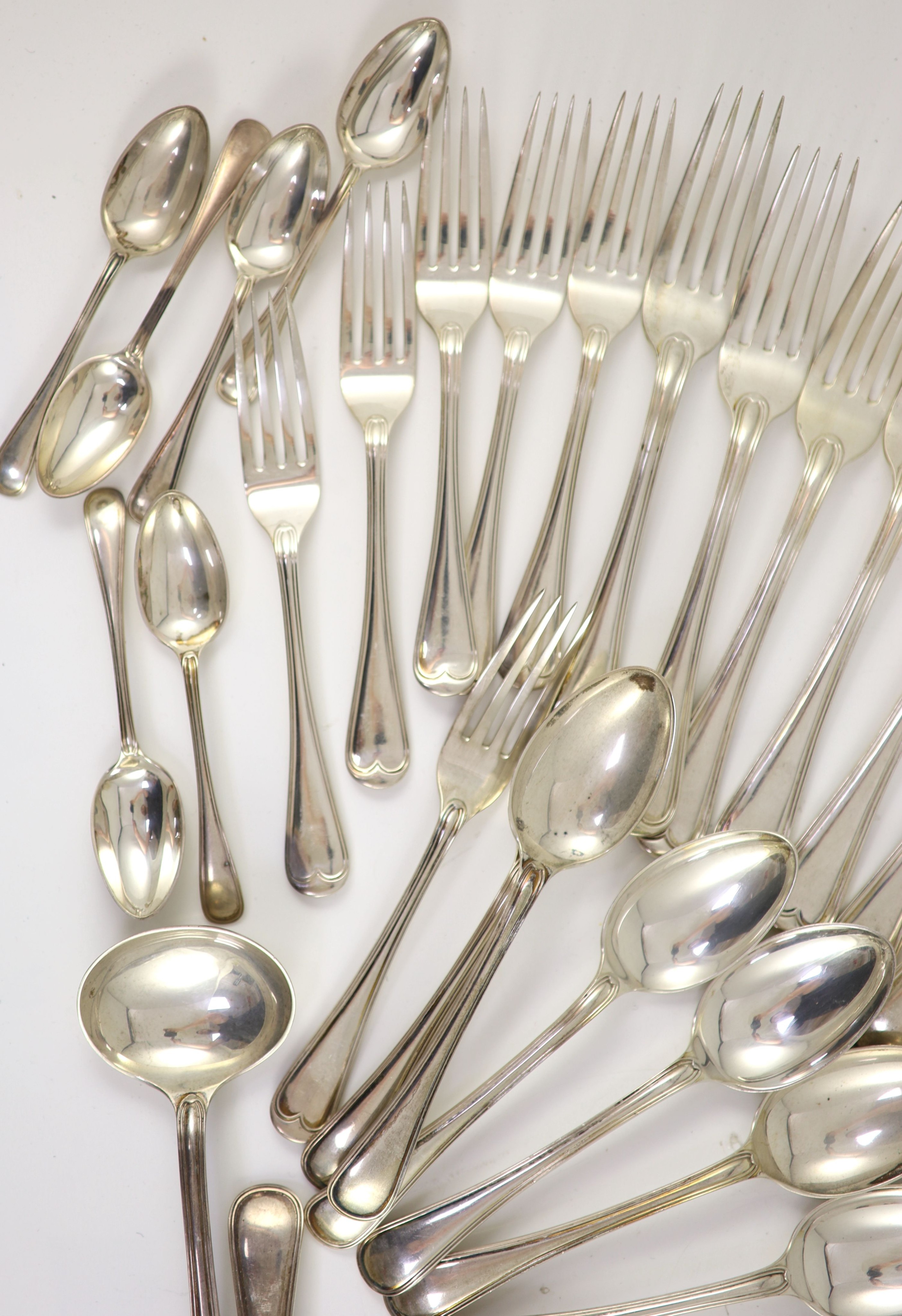 A part canteen of Edwardian silver Old English double struck thread pattern flatware for twelve by John Round & Son Ltd
